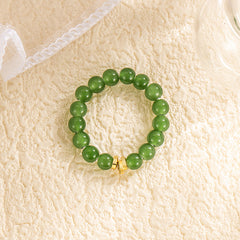 Jade Bead Ring – light green Hetian jade beads with gold barrel accent, cream textured surface, white lace fabric, minimalist feng shui