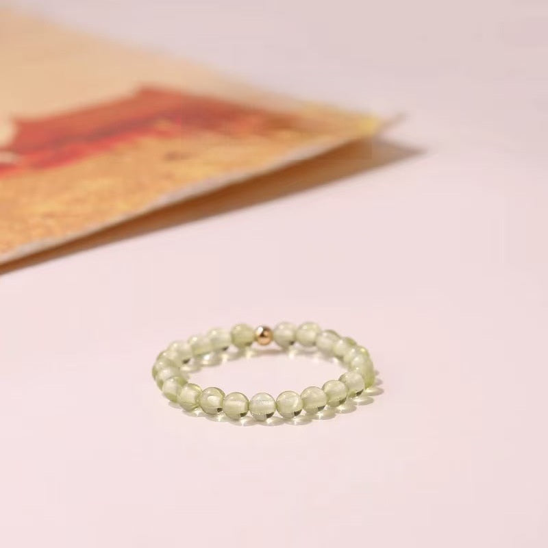Aventurine Ring – Light green aventurine bead ring with gold accent bead on pink background, heart chakra ring