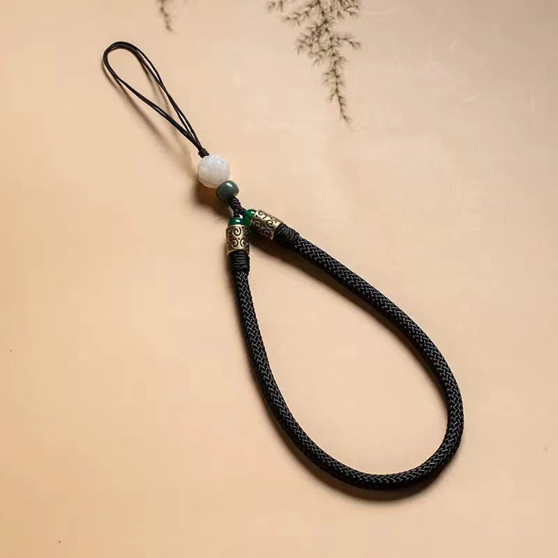 Lotus Bodhi Lanyard – Black herringbone woven lanyard with white bodhi lotus and patina brass details, meditation phone charm