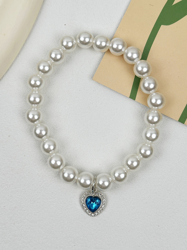 Quartz Heart Pearl Pet Collar – Pearl bead collar with blue crystal heart pendant on white fabric, cat collar