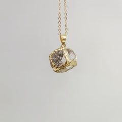 Gemstone Chip Pendant – Clear quartz raw crystal cube in gold rim on chain, gray background, healing necklace