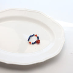 Lapis Lazuli Agate Ring Set – blue lapis ring featuring multiple round red agate beads and gold accents on white scalloped plate