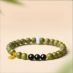 Green Sandalwood Bracelet – Single wrap with black obsidian center beads, gold accent on beige background