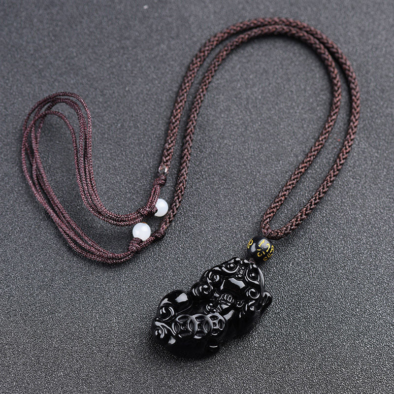 Obsidian Pixiu Necklace – Brown braided cord with obsidian pixiu pendant, white bead adjusters on gray