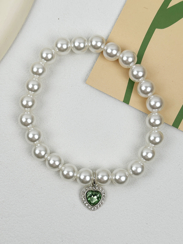 Quartz Heart Pearl Pet Collar – Pearl collar with green crystal heart pendant on white fabric, pet charm