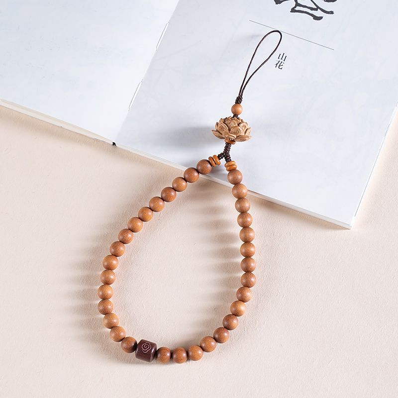 Zodiac Wood Bead Lanyard – Light peach wood bead lanyard with lotus crown on minimalist book, gentle zen phone accessory
