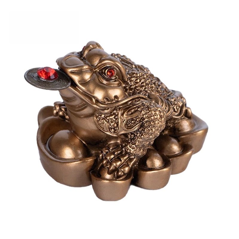 Bronze Money Toad – dark copper three-legged frog with red eyes biting coin on ingots, white background