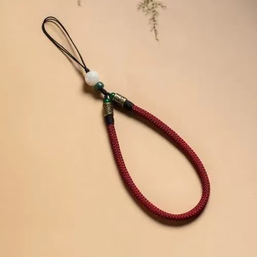 Lotus Bodhi Lanyard – Crimson red woven strap with white carved lotus bodhi bead on cream backdrop, vitality phone accessory