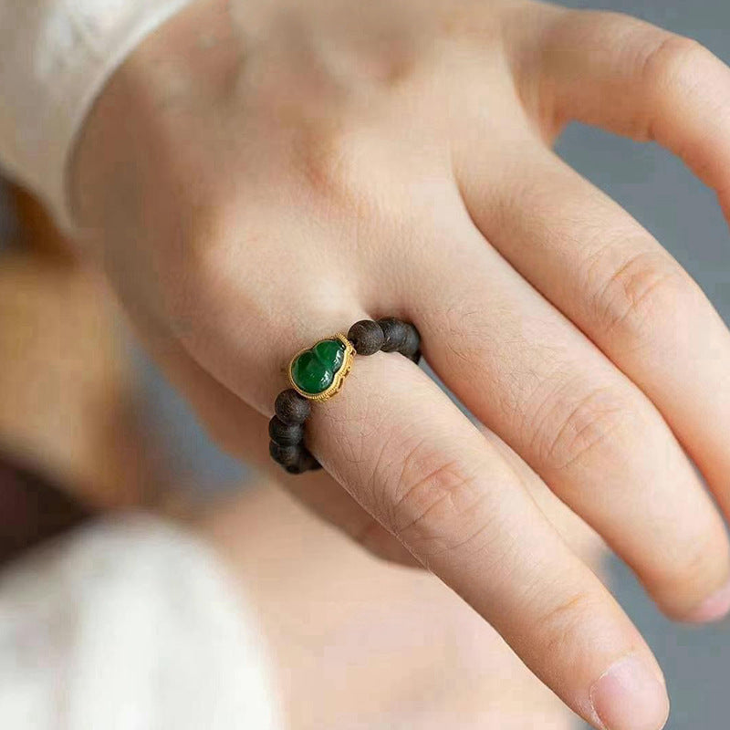 Agarwood Ring – dark wood beads with green jade gourd charm in gold setting, elegant feng shui ring
