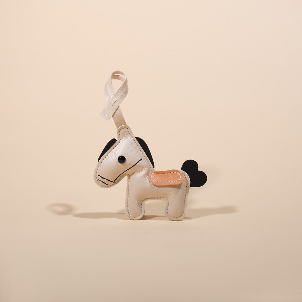 Feng Shui Leather Horse Keychain – White PU leather horse keychain on beige background, minimalist charm