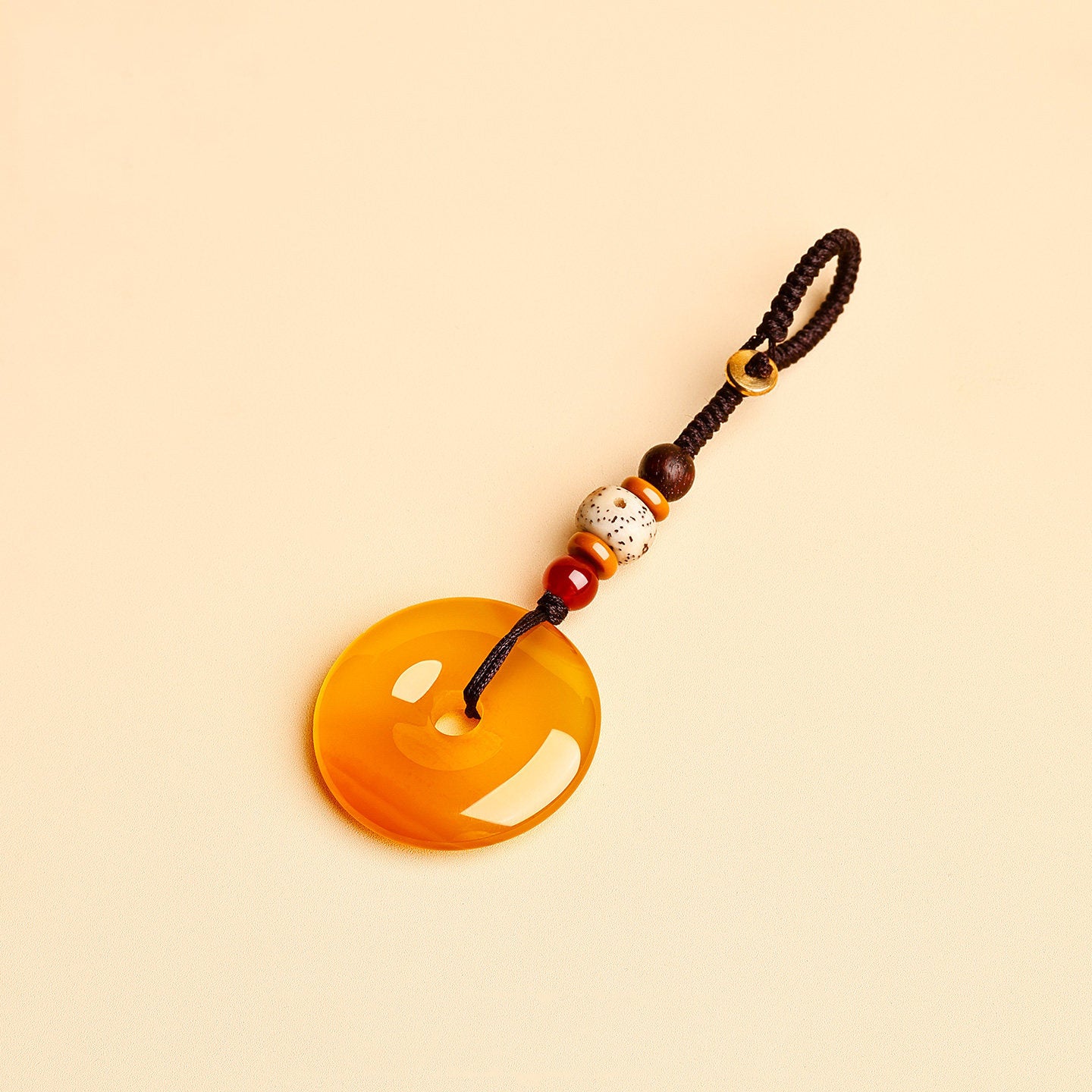 Jade Keychain Pendant – Yellow amber jade donut pendant with braided cord and bodhi beads on beige, fortune charm