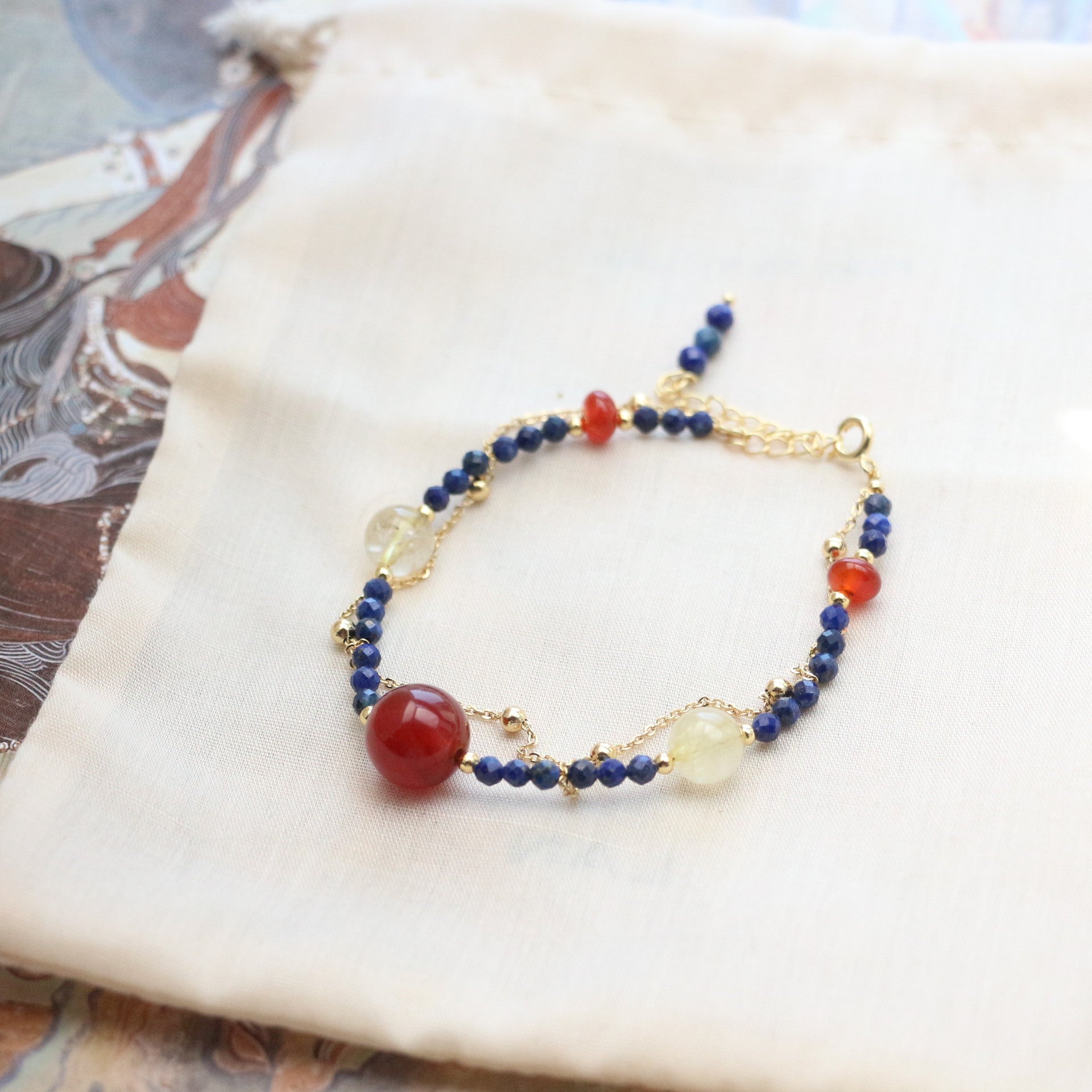 Lapis Lazuli Agate Bracelet – double-strand design with red agate, clear quartz and blue lapis lazuli beads, gold clasp, cream fabric