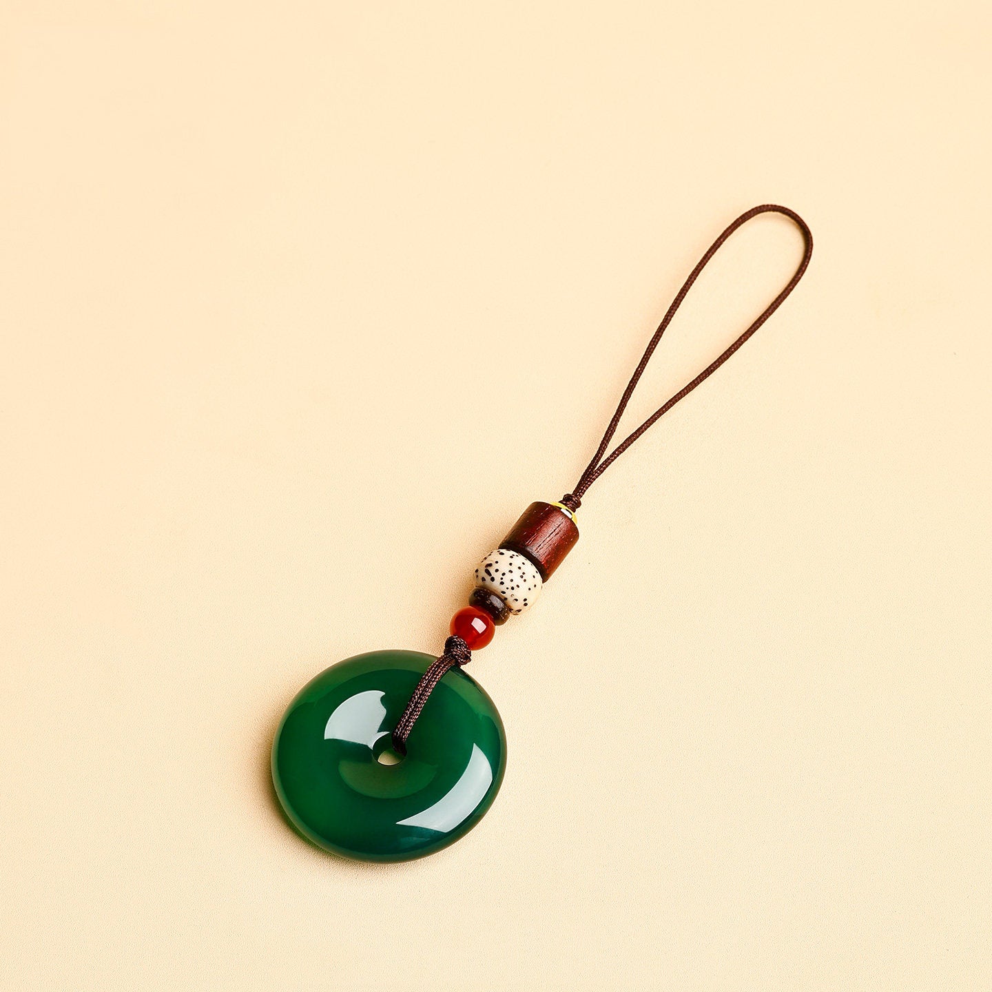 Jade Keychain Pendant – Green jade donut with slim cord and red agate beads on beige, spiritual keychain gift