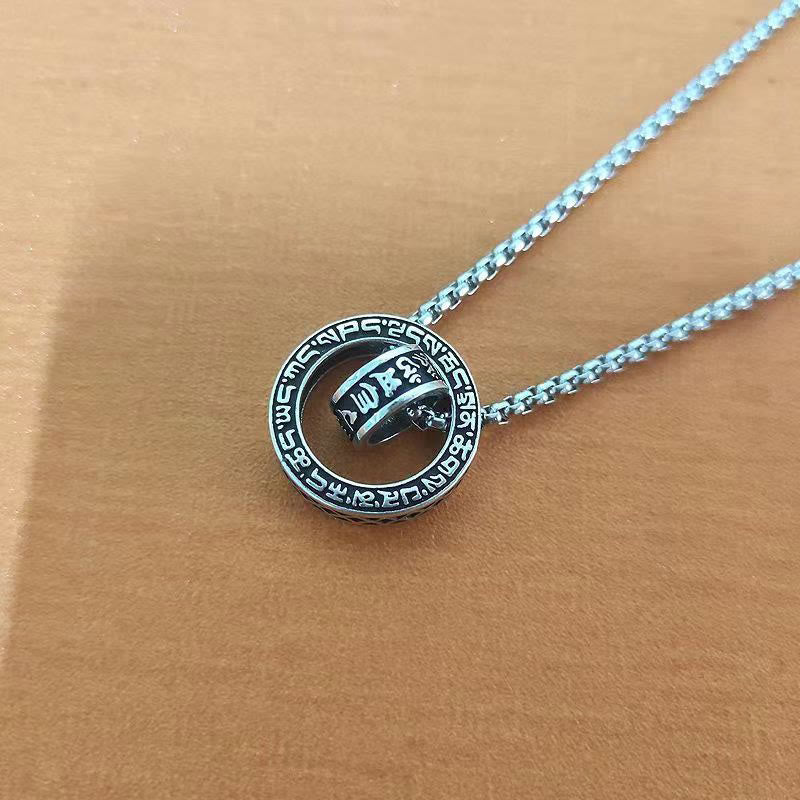Om Mani Padme Hum Silver Pendant Necklace – Silver mantra pendant flat lay on tan leather, overhead view showing engraved cylinder detail