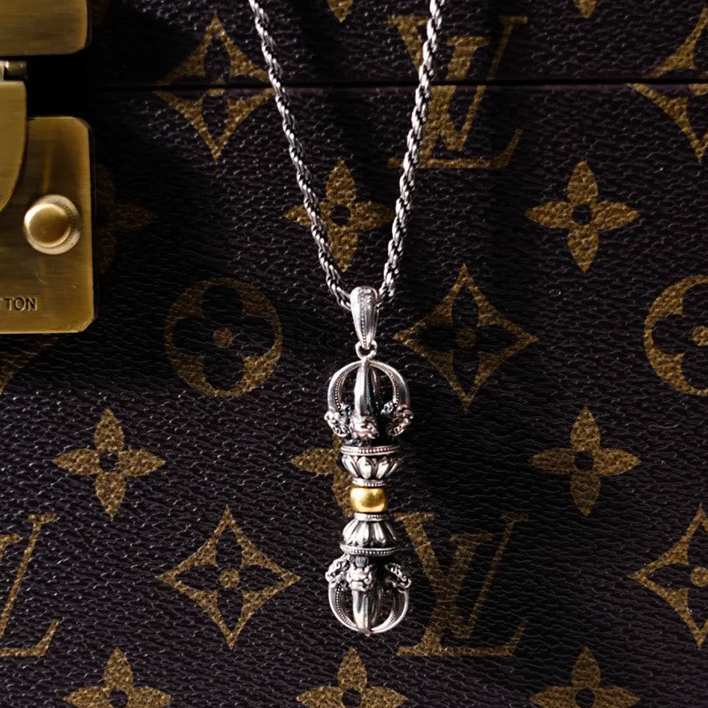Tibetan Vajra Dorje Pendant Necklace – Oxidized silver vajra with gold band held in weathered hands, dramatic chiaroscuro lighting