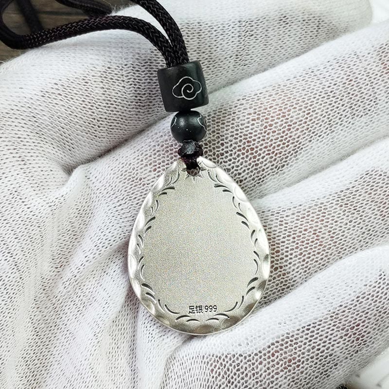 Yin Yang Bagua Water Drop Necklace – 999 fine silver teardrop pendant with wave-pattern border and cloud motif bead, white fabric glove showing purity stamp, top-down