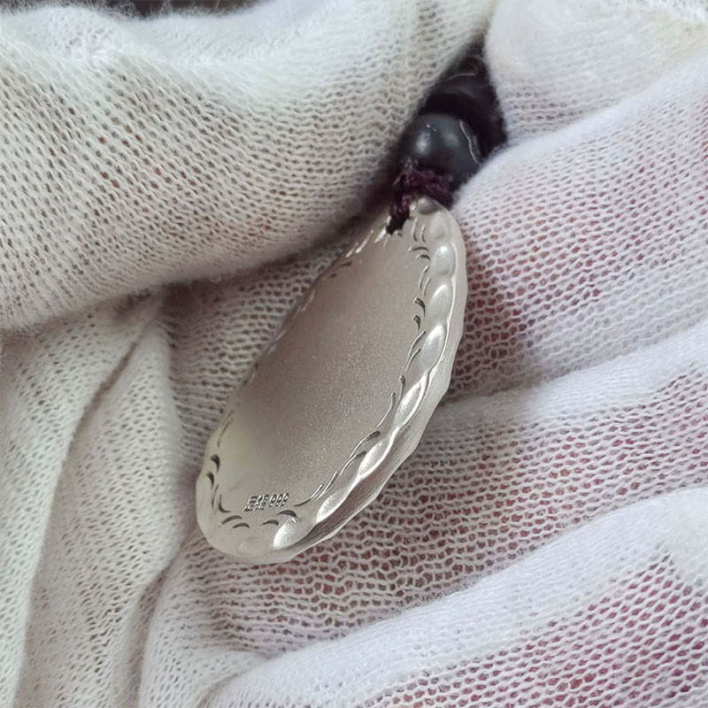 Yin Yang Bagua Water Drop Necklace – 999 silver oval pendant with scalloped braided border engraving and purity mark on black cord, white glove fabric overhead