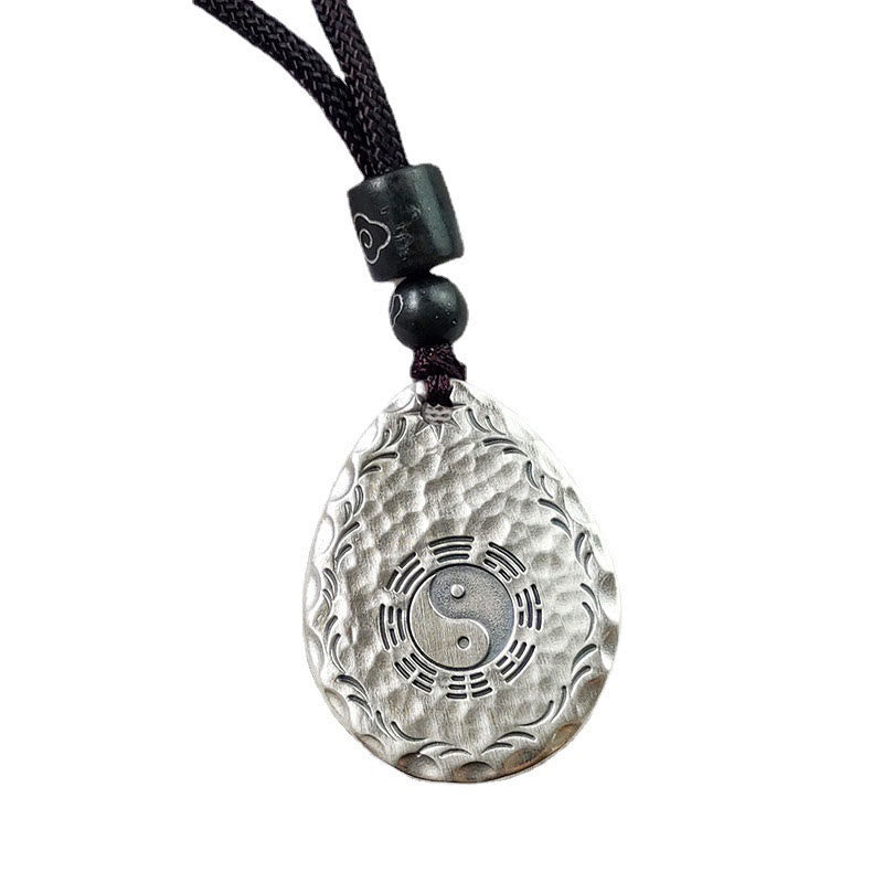 Yin Yang Bagua Water Drop Necklace – Silver teardrop yin-yang bagua pendant with wave border on black cord with dark beads, pure white background frontal view
