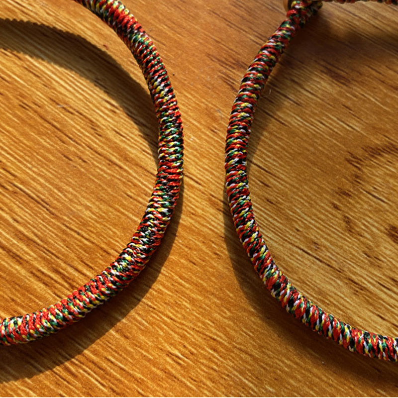 Chinese Zodiac Natal Buddha Bracelet – Multicolor braided cord necklace in red green yellow black threads, spiral weave on wooden surface